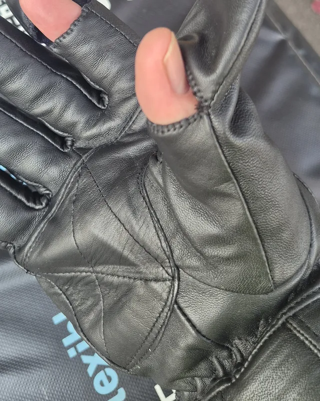 A repaired black leather glove